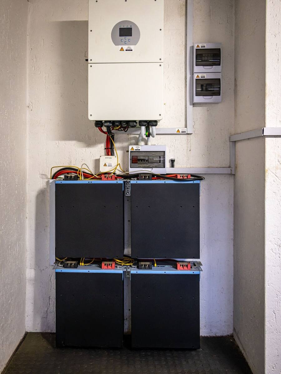 Onduleur solaire mural installé au-dessus d’un ensemble de batteries de stockage
