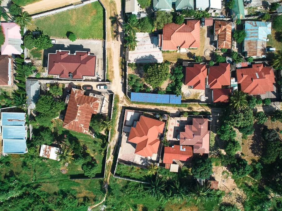 Vue aérienne d’un quartier résidentiel aux toitures de tuiles, entouré de végétation