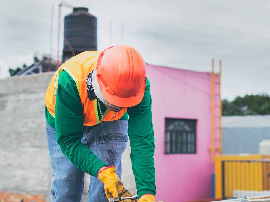 Technicien casqué intervenant sur un panneau solaire en toiture